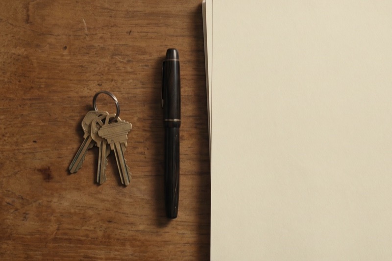 House keys, a pen, and documents on a desk