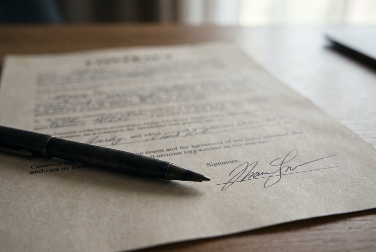A pen resting on a signed contract page