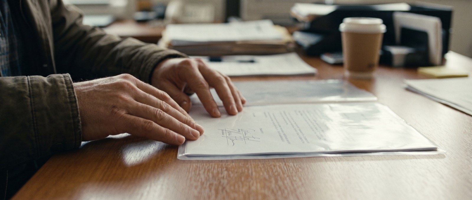 Hands placing a signed document into a protective folder