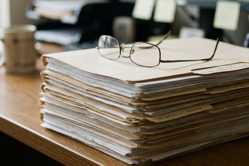 A stack of organized document folders on a desk being prepared for a lawyer review