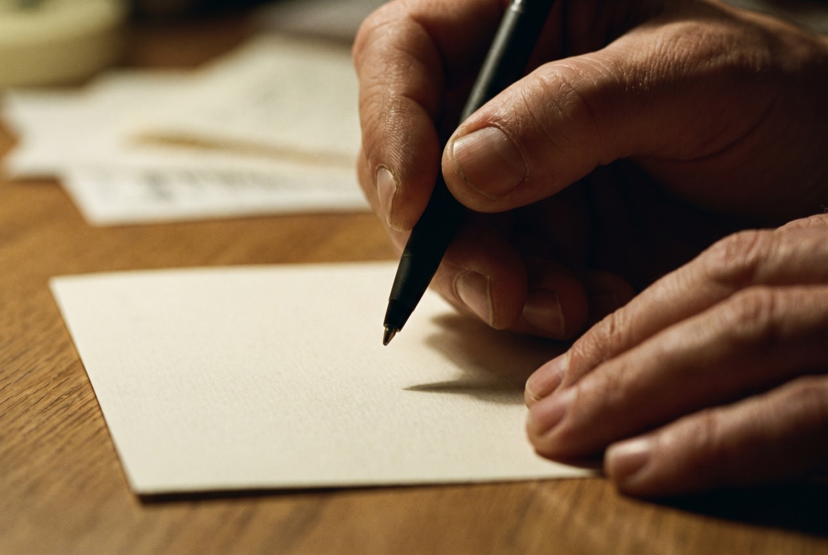 Close-up of hands over a price sheet with a pen